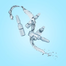 Image of Ampoules and splash of liquid in air on light blue background