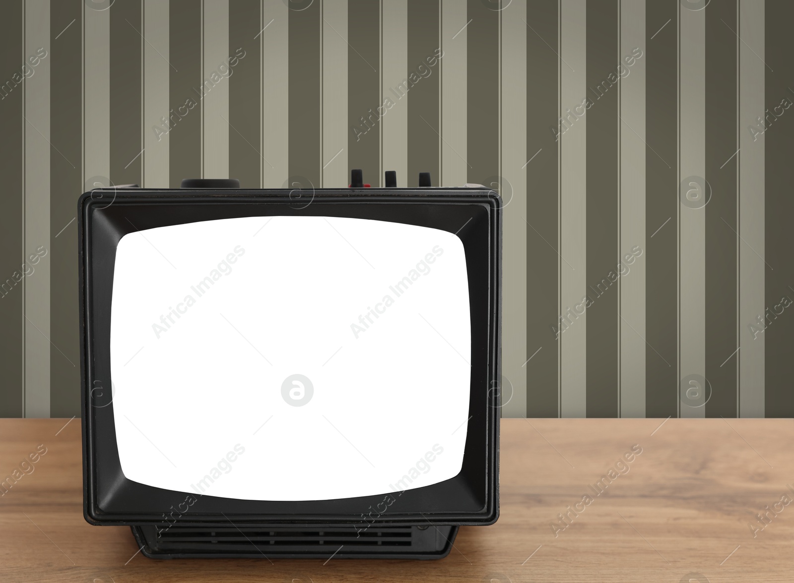 Image of Retro TV on wooden table near wall with vintage style wallpaper. Space for text