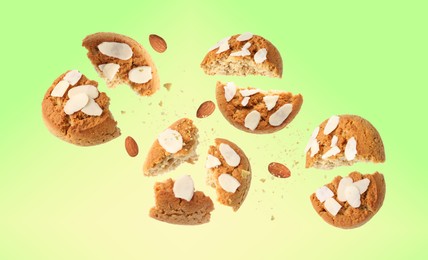 Image of Yummy nut cookies with almond petals in air on green yellow gradient background