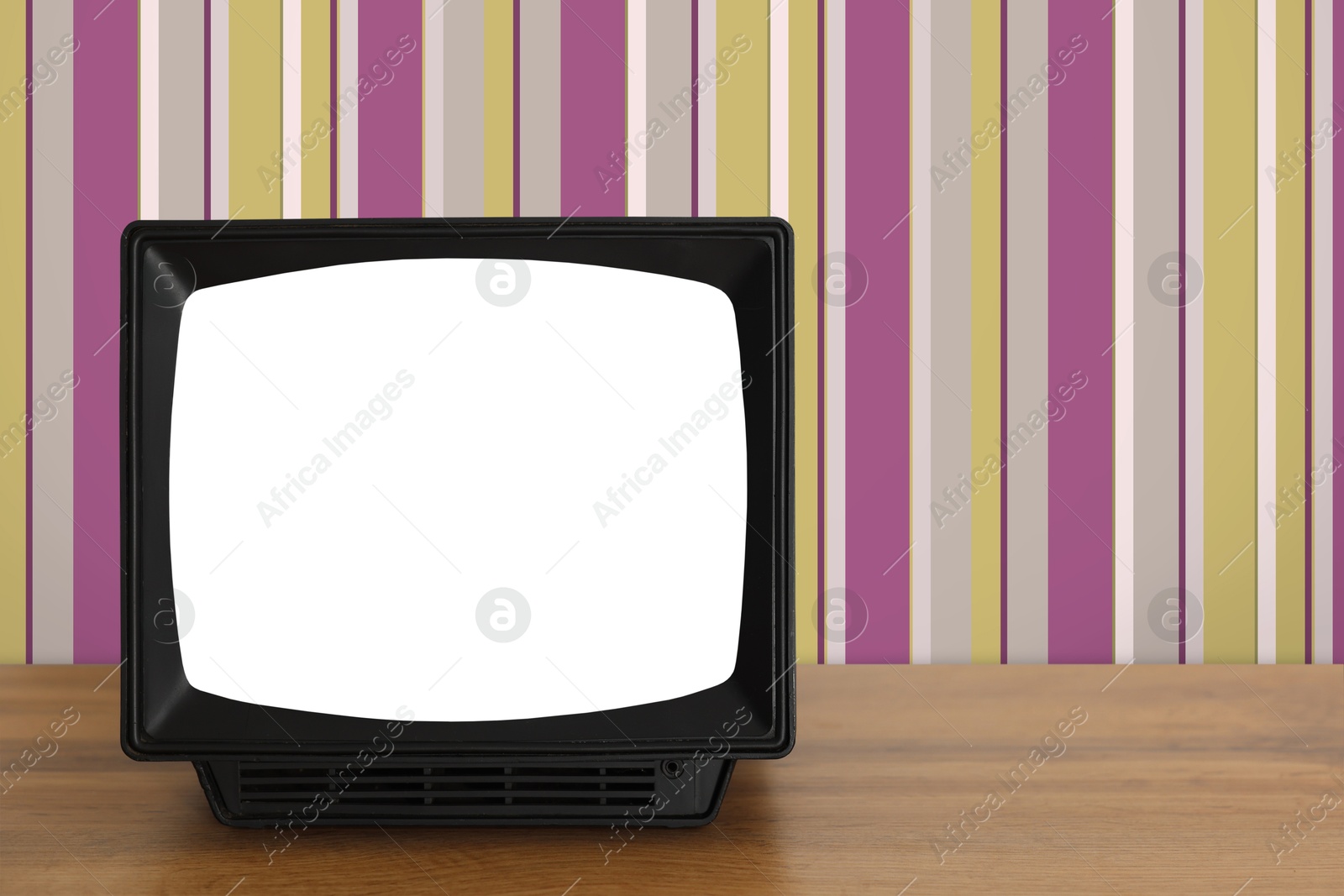 Image of Retro TV on wooden table near wall with vintage style wallpaper. Space for text