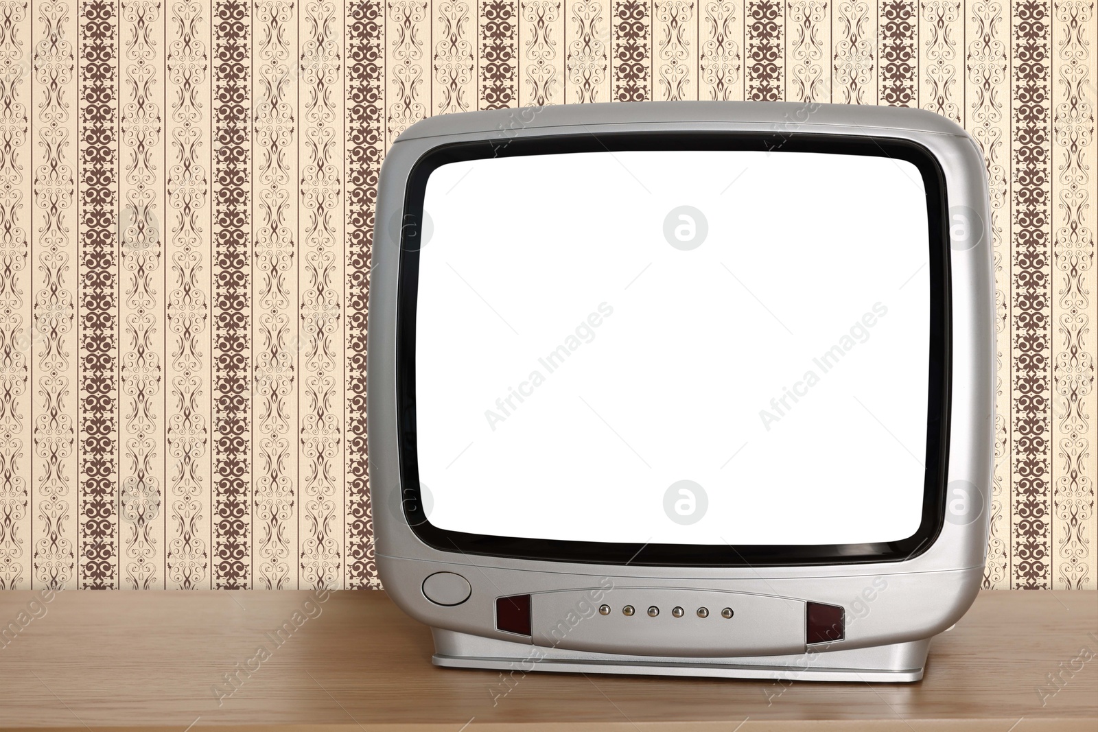 Image of Retro TV on wooden table near wall with vintage style wallpaper. Space for text