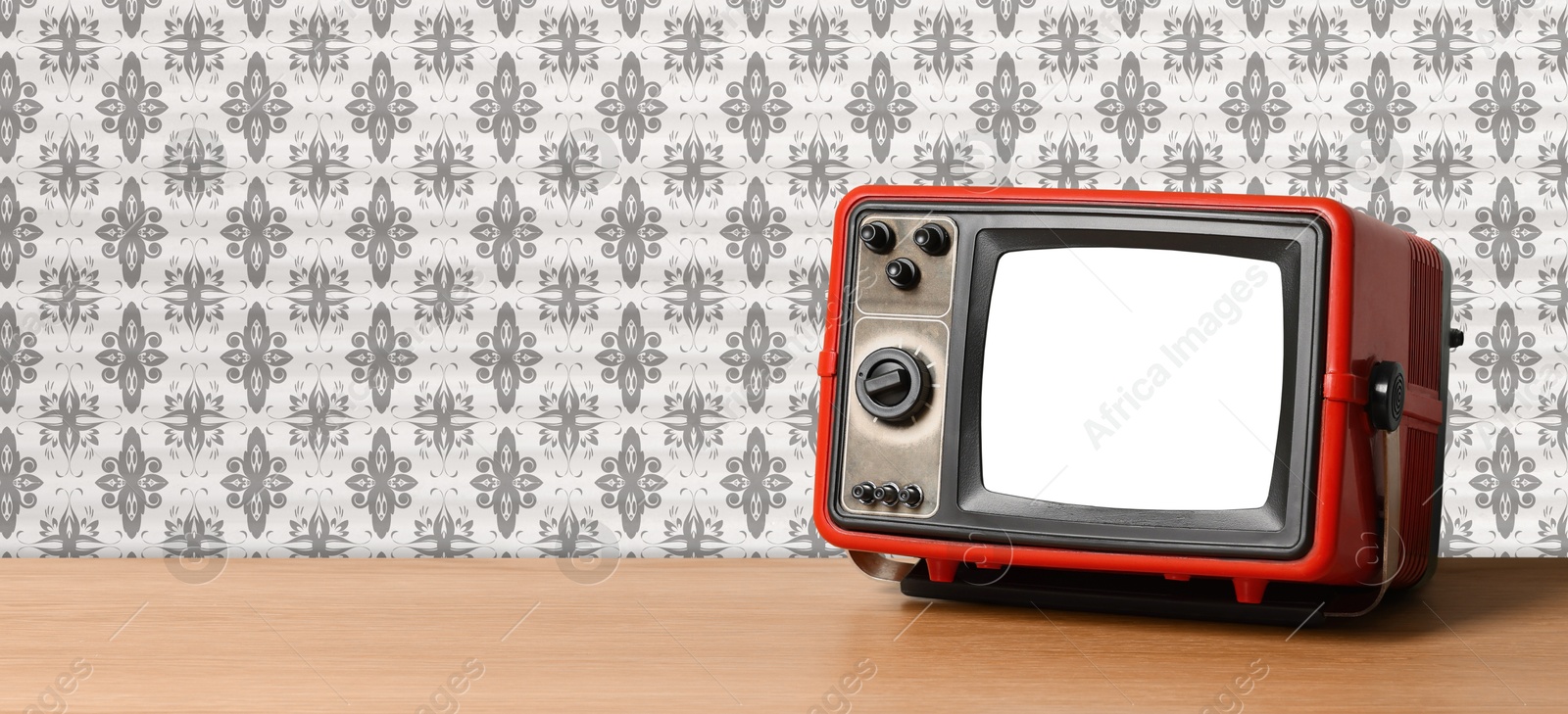 Image of Retro TV on wooden table near wall with vintage style wallpaper. Banner design with space for text