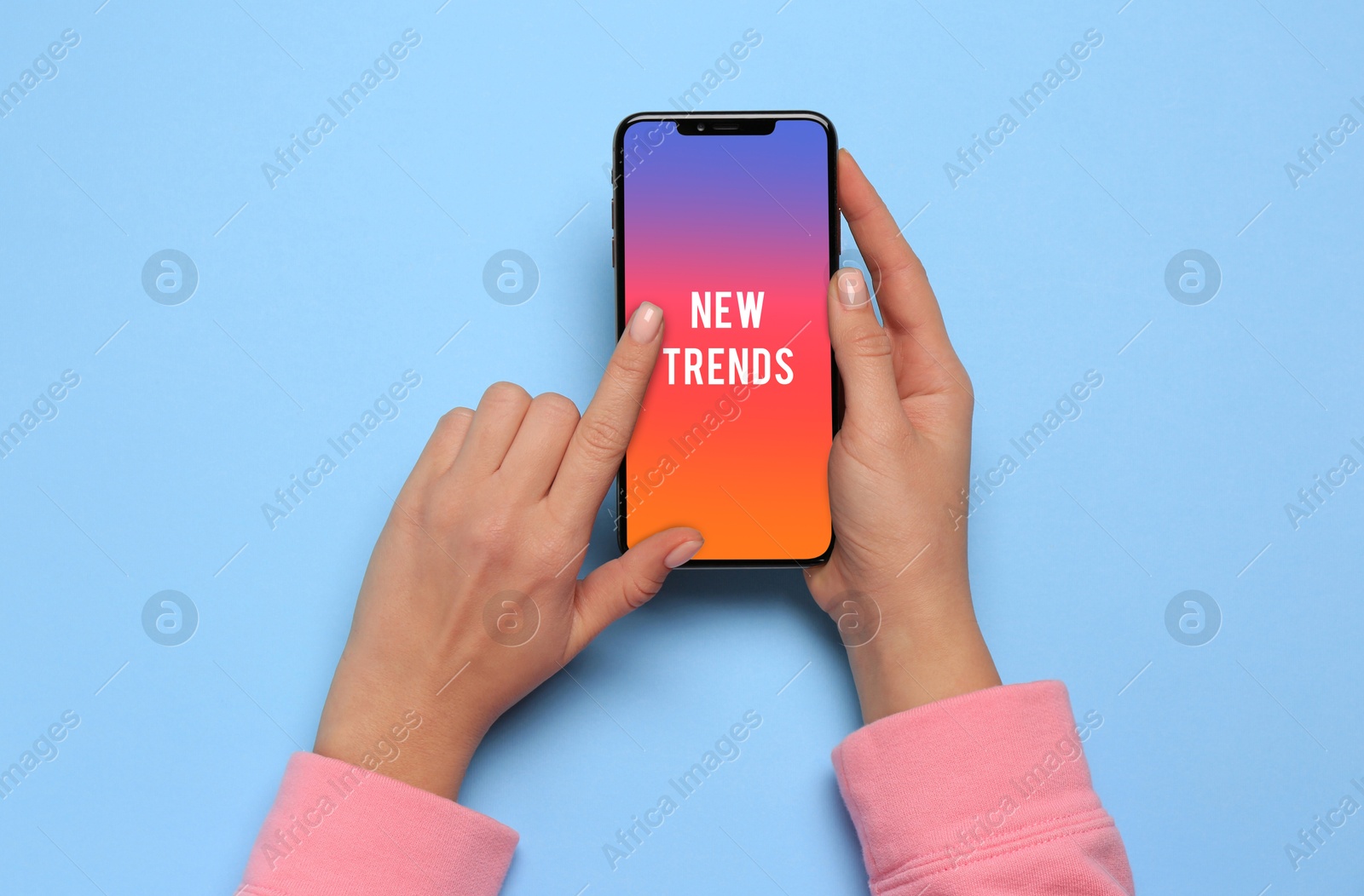 Image of New trends. Woman using smartphone on blue background, top view