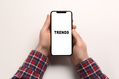 Image of New trends. Man using smartphone on white background, top view