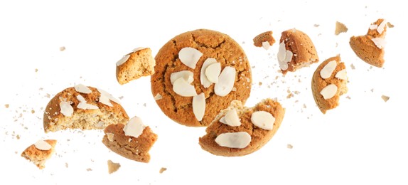 Image of Yummy nut cookies with almond petals in air on white background