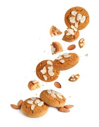 Yummy nut cookies with almond petals in air on white background