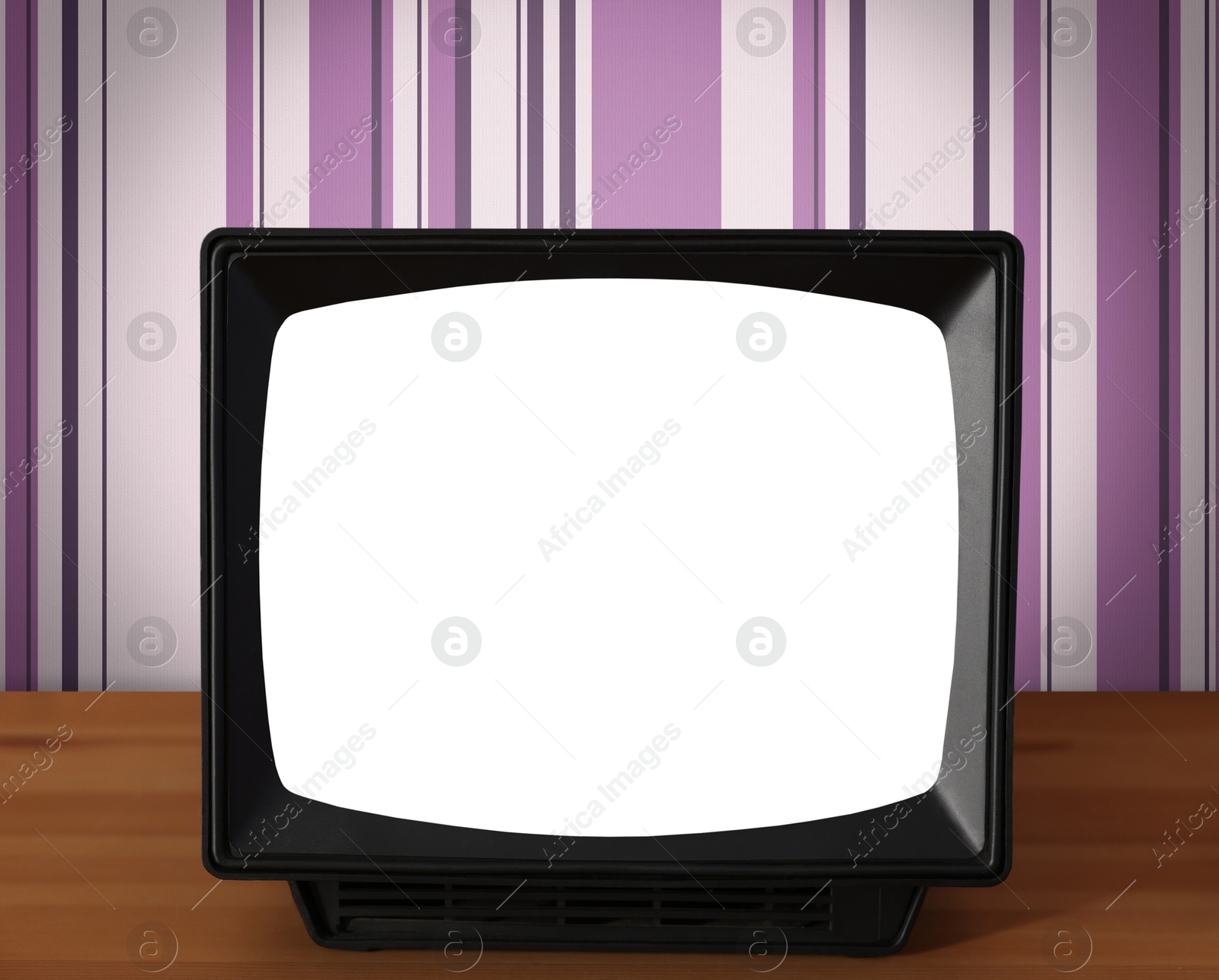 Image of Retro TV on wooden table near wall with vintage style wallpaper