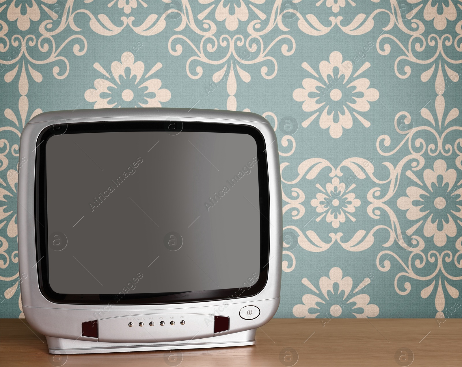 Image of Retro TV on wooden table near wall with vintage style wallpaper. Space for text