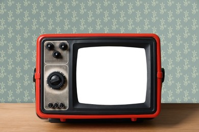 Image of Retro TV on wooden table near wall with vintage style wallpaper