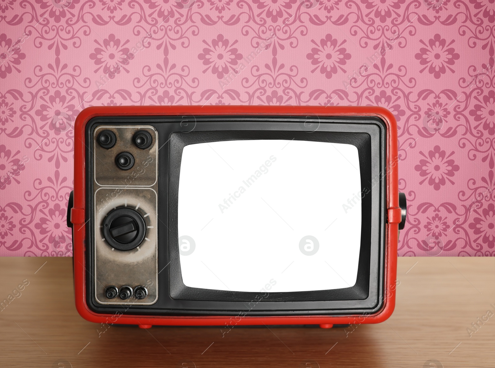 Image of Retro TV on wooden table near wall with vintage style wallpaper