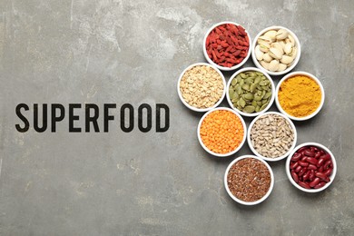 Image of Superfood. Different healthy food products in bowls on grey table, flat lay