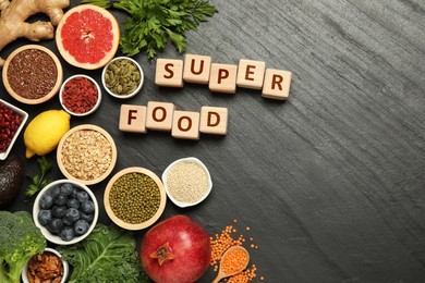 Image of Superfood. Different healthy food products and wooden cubes on grey table, flat lay