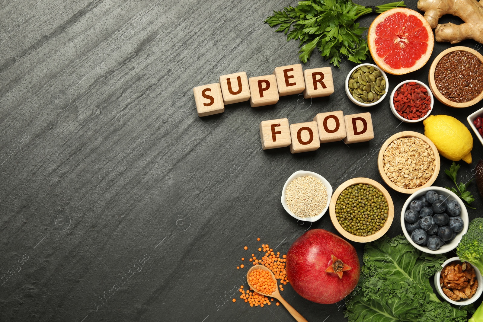 Image of Superfood. Different healthy food products and wooden cubes on grey table, flat lay