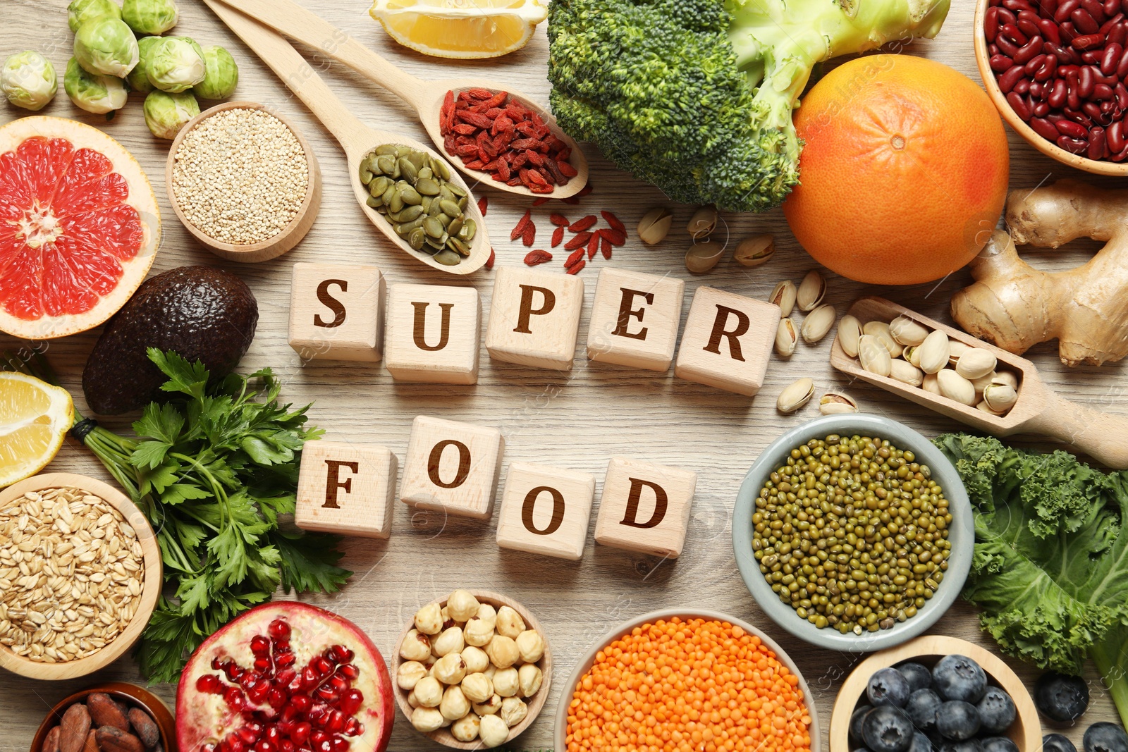 Image of Superfood. Different healthy food products and cubes on wooden table, flat lay