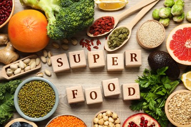 Image of Superfood. Different healthy food products and cubes on wooden table, flat lay