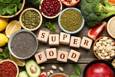 Image of Superfood. Different healthy food products and cubes on wooden table, flat lay