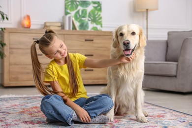 Photo of Girl with her cute Golden Retriever dog on rug at home