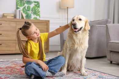 Photo of Girl with her cute Golden Retriever dog on rug at home