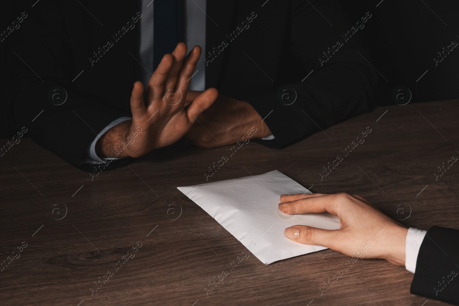 Photo of Corruption concept. Woman giving envelope with money to man at wooden table, closeup