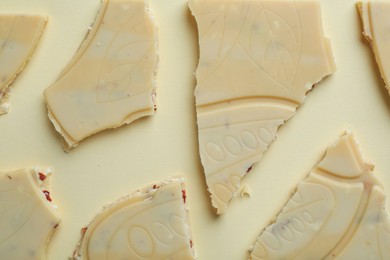 Photo of Pieces of tasty white chocolate on beige background, top view