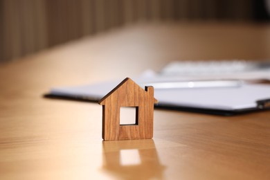 Photo of Property insurance. House figure on wooden table