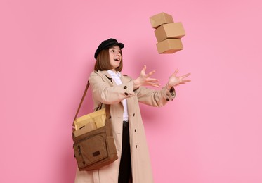 Photo of Funny postwoman with bag throwing parcels on pink background