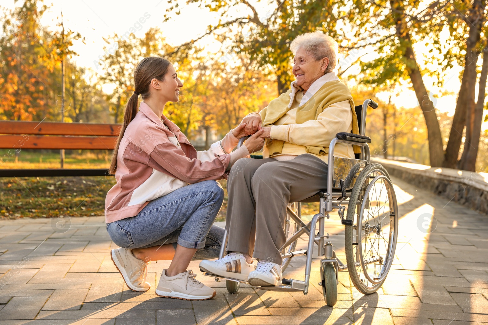 Photo of Caregiver with elderly woman in wheelchair at park