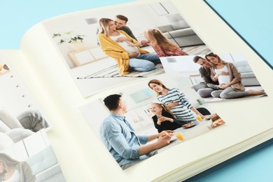 Photo of Open photo album with different photos on light blue background