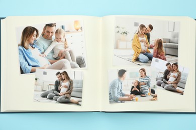 Photo of Open photo album with different photos on light blue background, top view