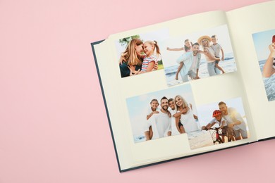 Photo of Open photo album with different photos on pink background, top view. Space for text