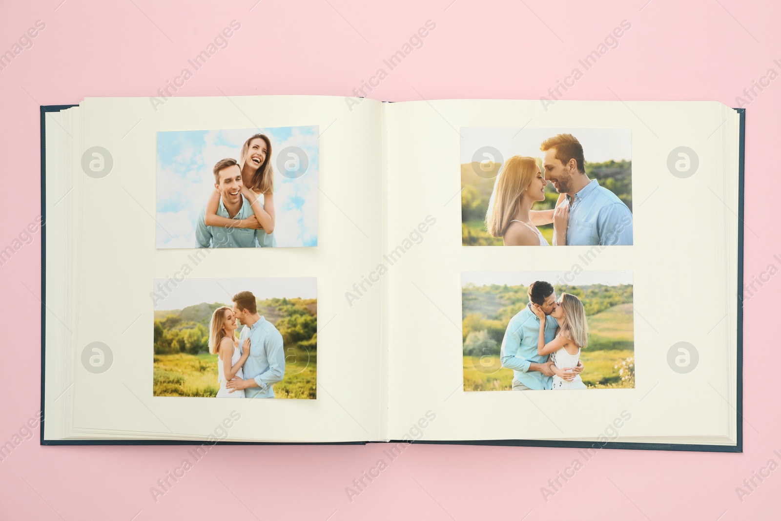 Photo of Open photo album with different photos on pink background, top view