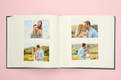 Open photo album with different photos on pink background, top view