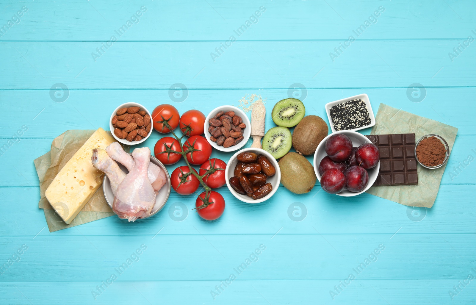 Photo of Different products rich in serotonin on light blue wooden table, flat lay