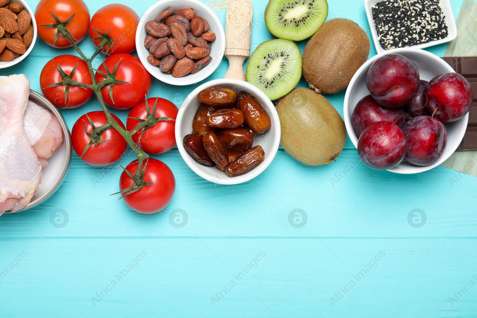 Photo of Different products rich in serotonin on light blue wooden table, flat lay. Space for text