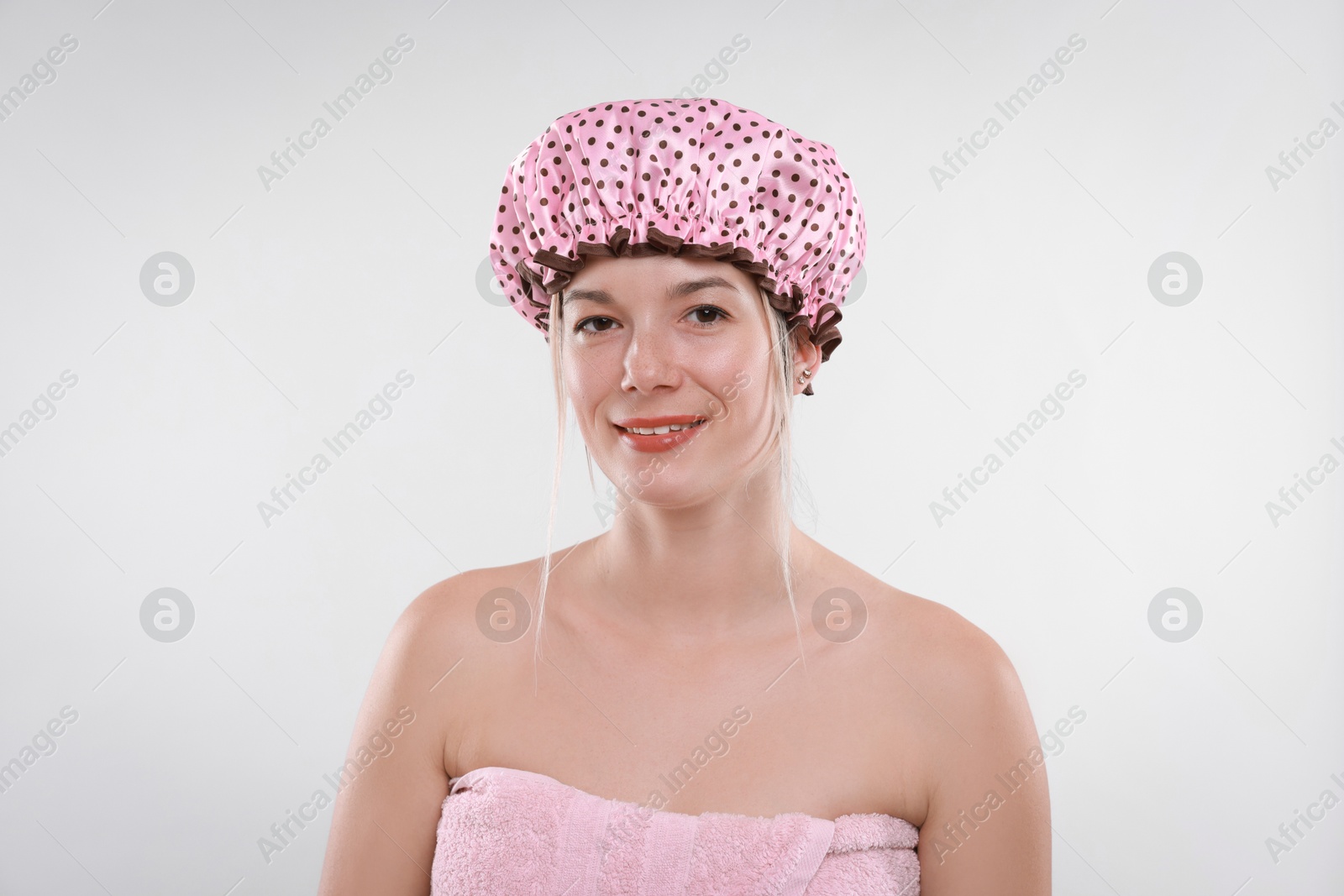 Photo of Happy woman in shower cap on white background