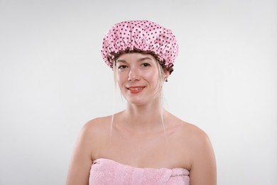 Photo of Happy woman in shower cap on white background