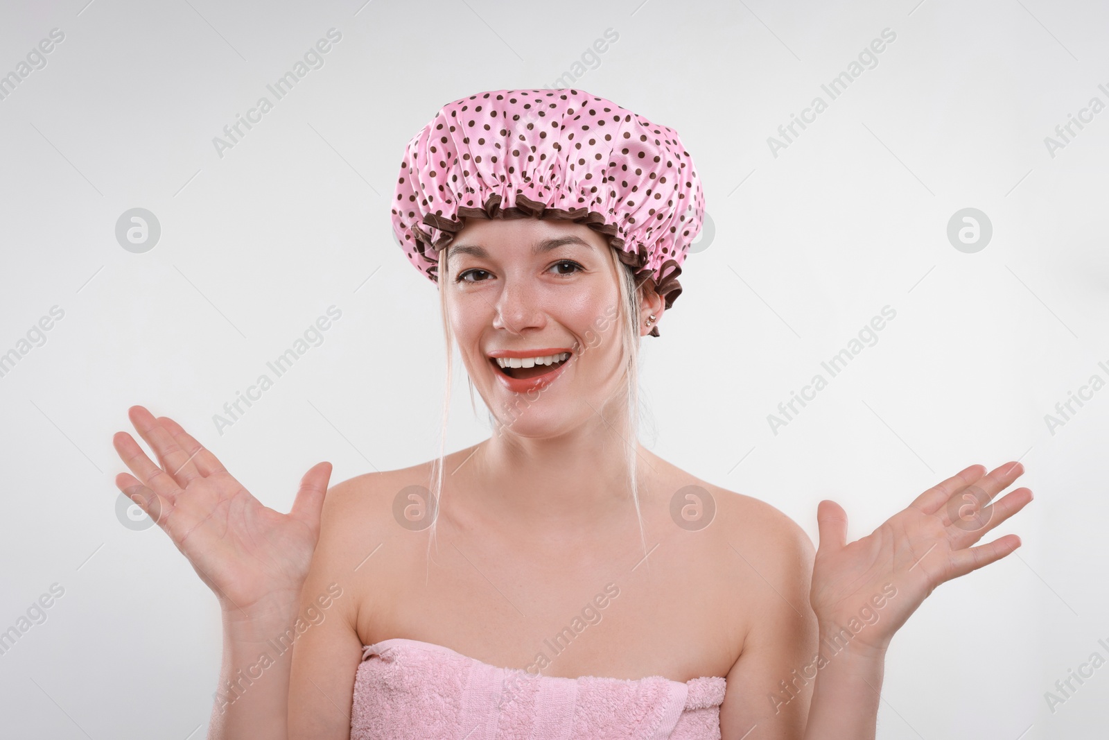 Photo of Happy woman in shower cap on white background