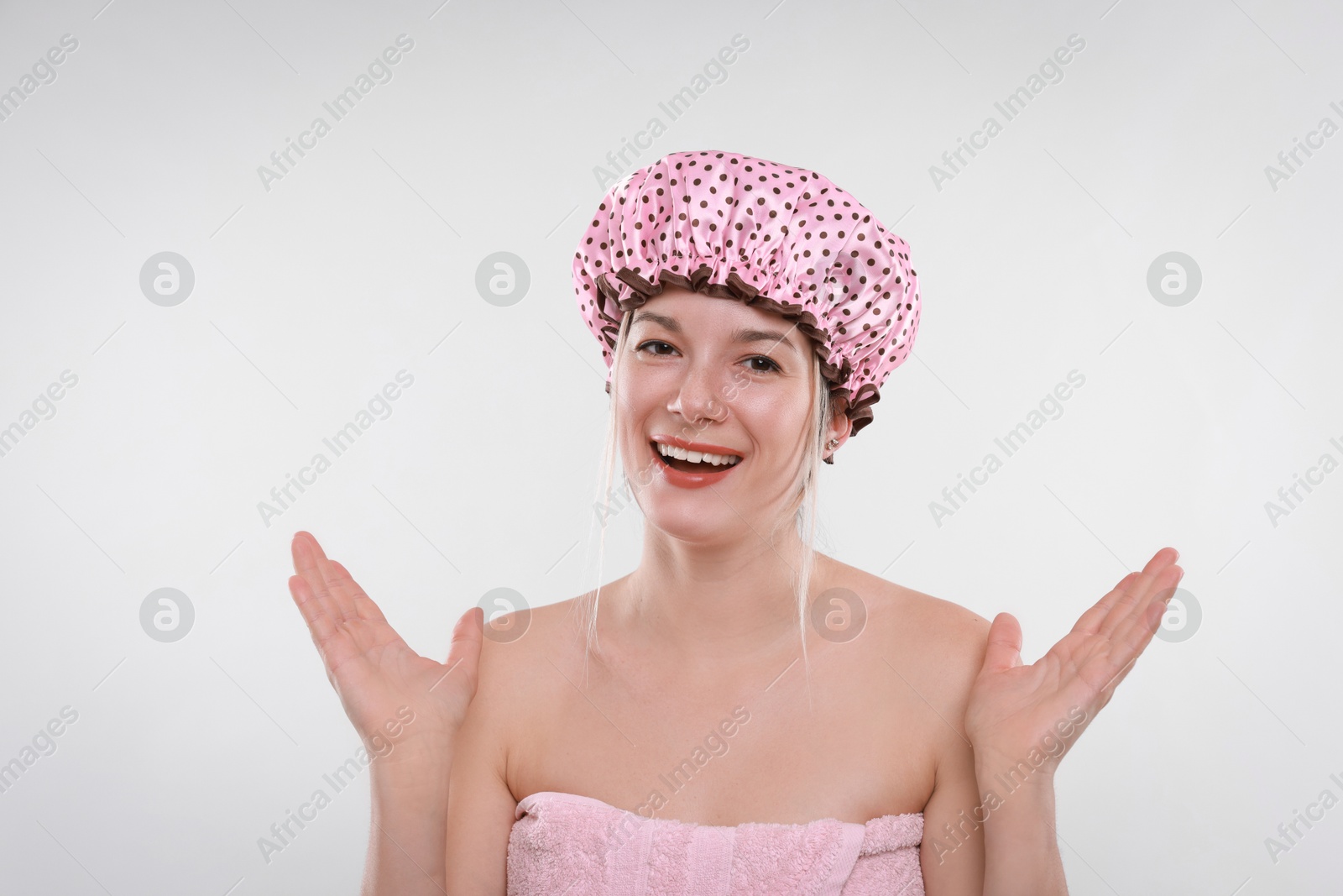 Photo of Happy woman in shower cap on white background