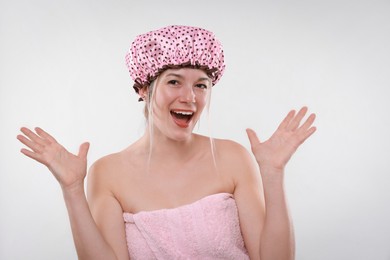 Photo of Happy woman in shower cap on white background