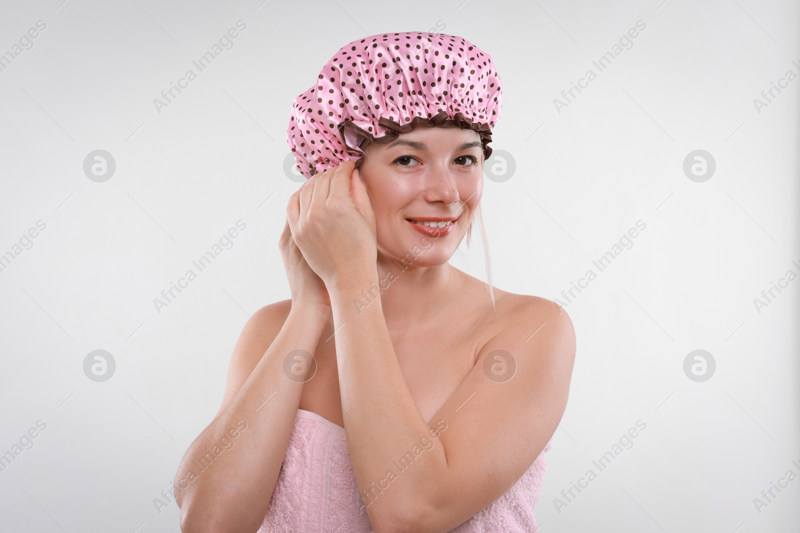 Photo of Woman wearing shower cap on white background