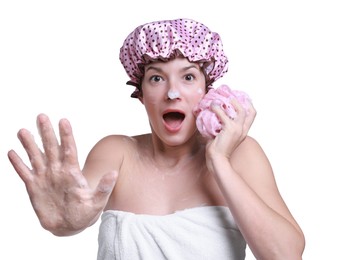 Photo of Woman with shower cap and mesh sponge making stop gesture on white background