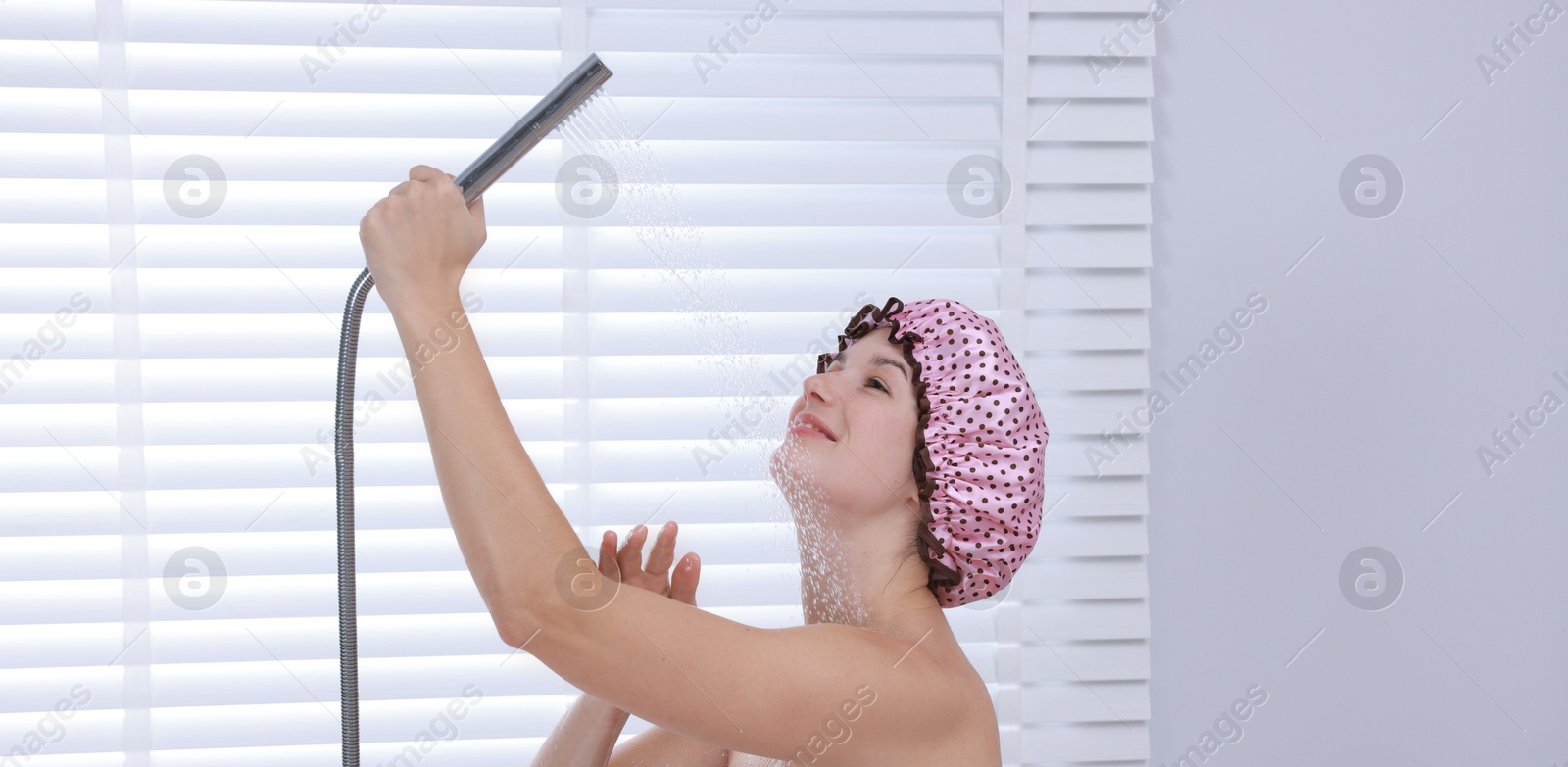 Photo of Woman with cap taking shower in bathroom