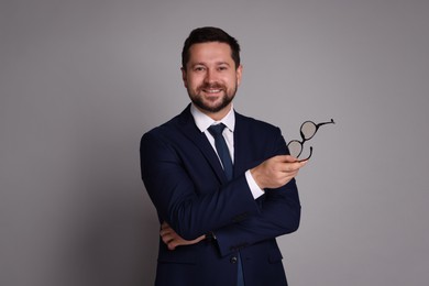 Photo of Portrait of banker with glasses on grey background