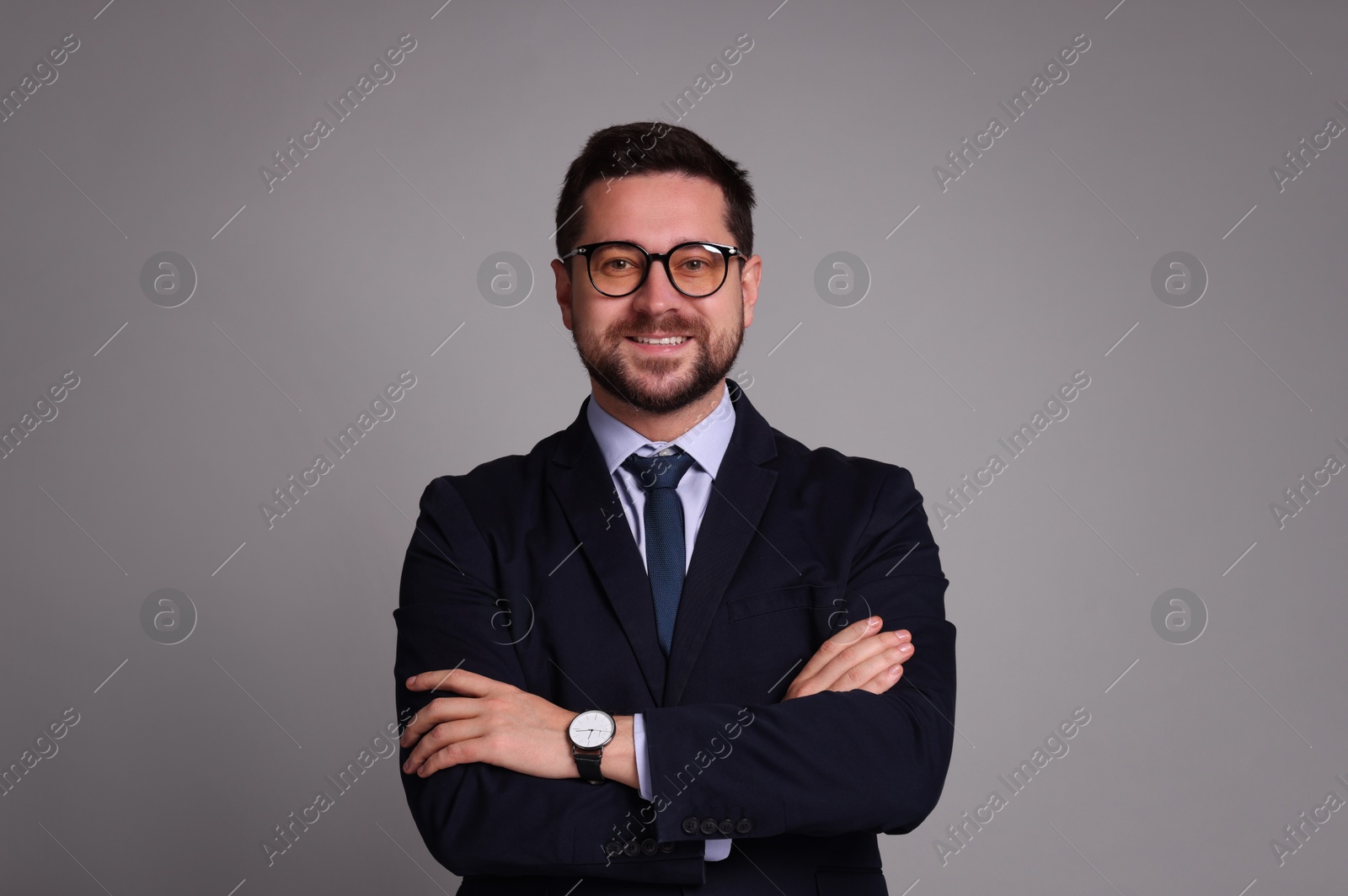 Photo of Portrait of banker with crossed arms on grey background