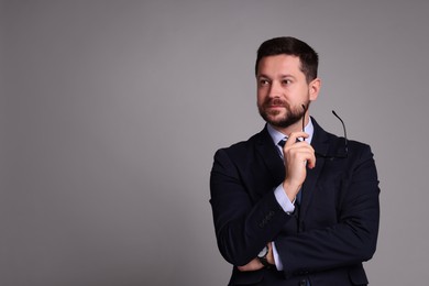 Photo of Portrait of banker with glasses on grey background, space for text