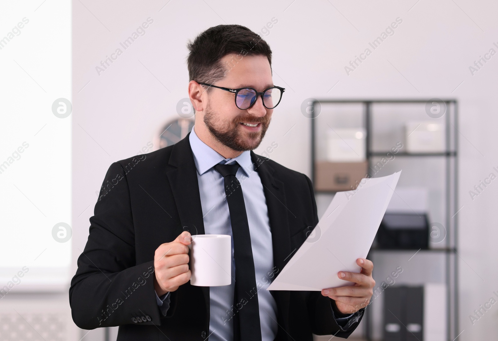 Photo of Banker with cup of drink and documents in office