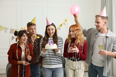 18th birthday. Group of happy friends with tasty cake having coming of age party at home