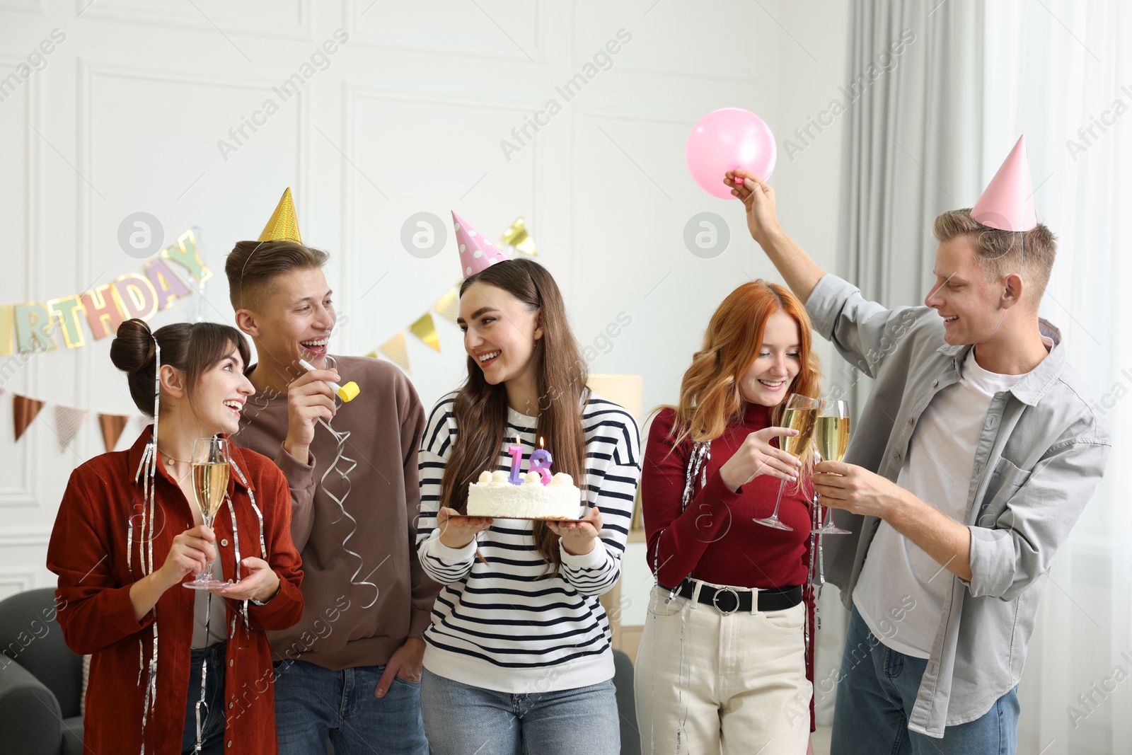 Photo of 18th birthday. Group of happy friends with tasty cake having coming of age party at home