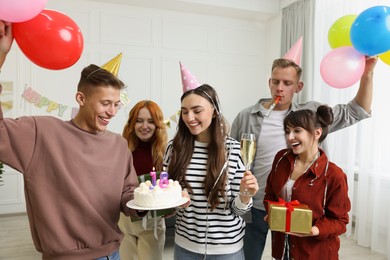 18th birthday. Group of friends with tasty cake having coming of age party at home