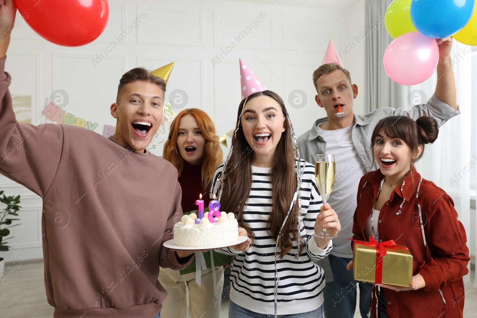 Photo of 18th birthday. Group of friends with tasty cake having coming of age party at home